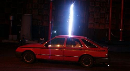 Here a car's metal body is acting as a Faraday Cage, protecting the occupants from the electric discharge.